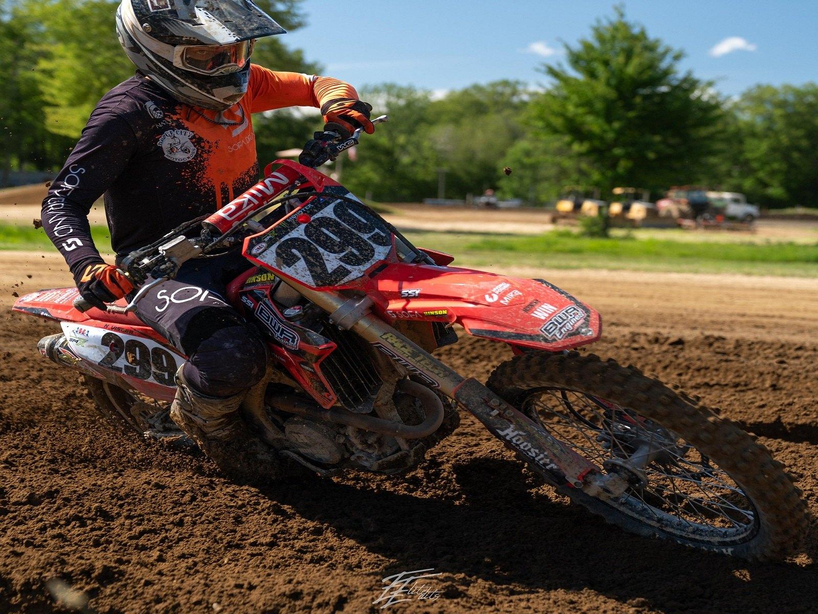 Rider leaning a red bike through a flat corner