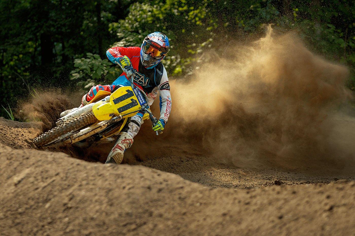 Rider on a yellow bike blasting a roost in a corner